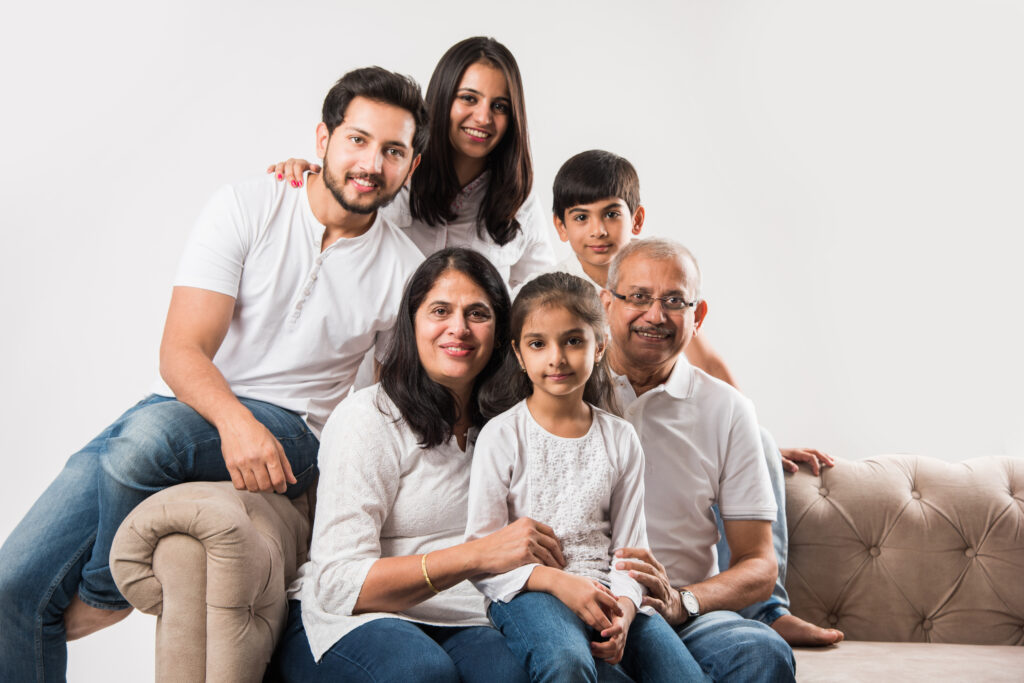 An image of a smiling, multigenerational Indian family sitting together represents love, harmony, and close emotional ties.